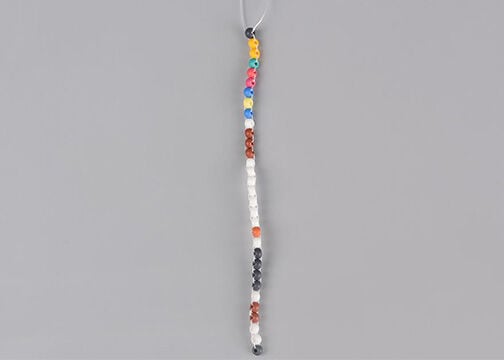 Column of multicolored seed beads with two threads coming out the top